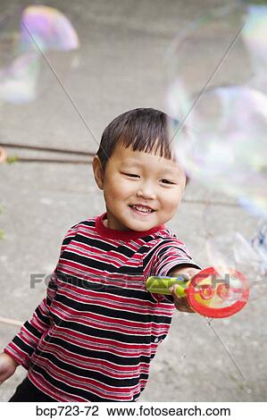 Young boy blowing bubbles View Large Photo Image Stock Image - Young boy blowing bubbles. Fotosearch