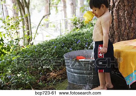 Young boy dumping water on himself View Large Photo Image Stock Image - Young boy dumping water on himself. Fotosearch