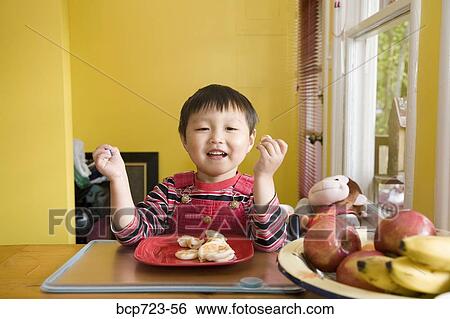 Stock Photograph - Young boy eating fruit. Fotosearch