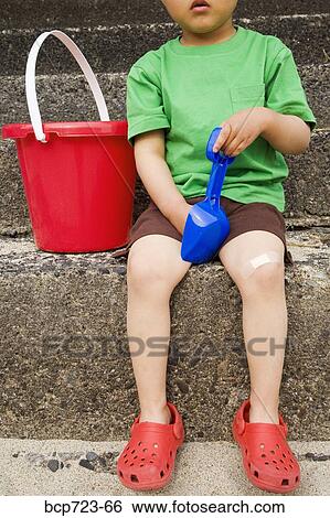 Young boy holding shovel and bucket View Large Photo Image Stock Photograph - Young boy holding shovel and bucket. Fotosearch