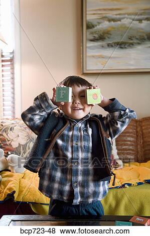 Young boy holding wooden blocks over his eyes View Large Photo Image Stock Photo - Young boy holding wooden blocks over his eyes. Fotosearch