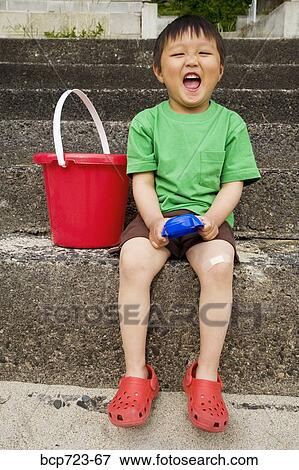 Stock Photo - Young boy laughing on steps. Fotosearch