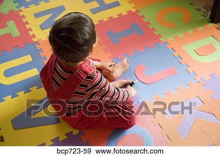 Young boy sitting on alphabet mat View Large Photo Image Stock Photo - Young boy sitting on alphabet mat. Fotosearch
