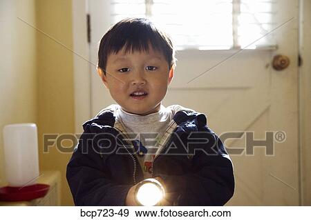Young boy using a flashlight View Large Photo Image Stock Photo - Young boy using a flashlight. Fotosearch