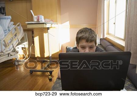 Young boy using a laptop in hospital room View Large Photo Image Stock Photo - Young boy using a laptop in hospital room. Fotosearch