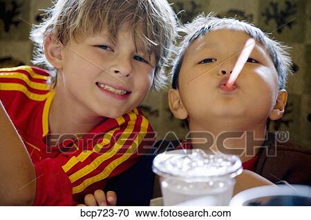 Stock Image - Young boys playing with straws. Fotosearch