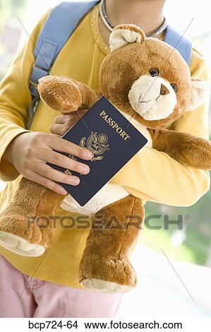 Young girl holding teddy bear and passport View Large Photo Image Picture - Young girl holding teddy bear and passport. Fotosearch