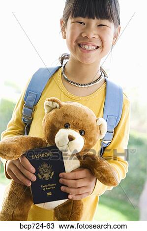 Young girl holding teddy bear and passport View Large Photo Image Stock Image - Young girl holding teddy bear and passport. Fotosearch