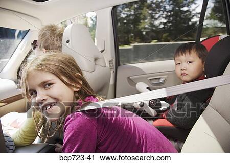 Young girl leaning forward in backseat of car View Large Photo Image Stock Image - Young girl leaning forward in backseat of car. Fotosearch
