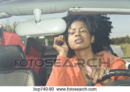 African woman applying mascara in car View Large Photo Image Stock Image - African woman applying mascara in car. Fotosearch