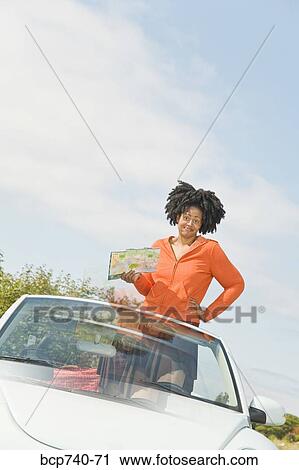 African woman holding map in convertible car View Large Photo Image Stock Image - African woman holding map in convertible car. Fotosearch