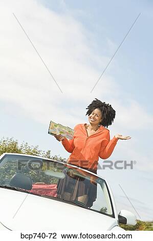 African woman holding map in convertible car View Large Photo Image Stock Image - African woman holding map in convertible car. Fotosearch