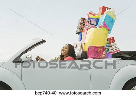 African woman in convertible with shopping bags View Large Photo Image Stock Image - African woman in convertible with shopping bags. Fotosearch