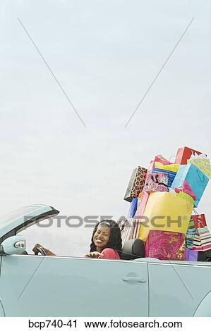 African woman in convertible with shopping bags View Large Photo Image Stock Image - African woman in convertible with shopping bags. Fotosearch
