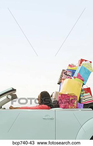 African woman in convertible with shopping bags View Large Photo Image Stock Image - African woman in convertible with shopping bags. Fotosearch