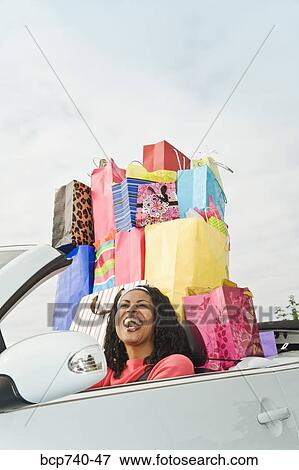 African woman in convertible with shopping bags View Large Photo Image Stock Photo - African woman in convertible with shopping bags. Fotosearch