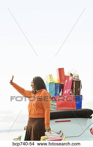 African woman next to convertible with shopping bags View Large Photo Image Picture - African woman next to convertible with shopping bags. Fotosearch