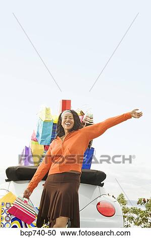 African woman next to convertible with shopping bags View Large Photo Image Stock Image - African woman next to convertible with shopping bags. Fotosearch