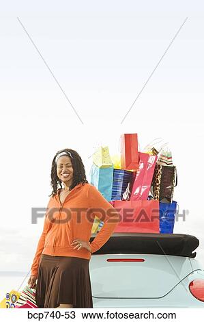 African woman next to convertible with shopping bags View Large Photo Image Stock Image - African woman next to convertible with shopping bags. Fotosearch