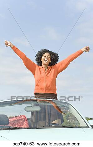 African woman with arms raised in convertible car View Large Photo Image Stock Image - African woman with arms raised in convertible car. Fotosearch