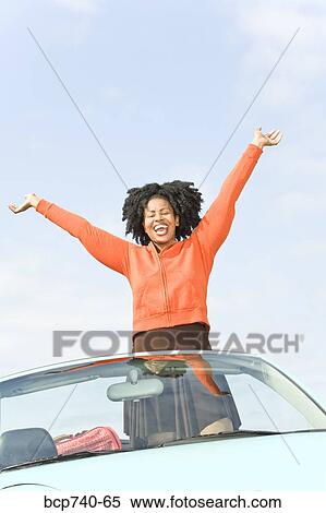 African woman with arms raised in convertible car View Large Photo Image Stock Photography - African woman with arms raised in convertible car. Fotosearch