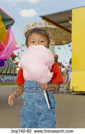 Stock Image - Asian boy eating cotton candy. Fotosearch