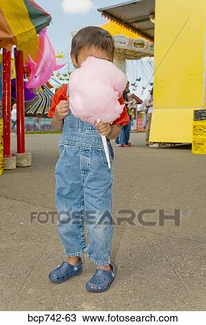 Stock Image - Asian boy eating cotton candy. Fotosearch