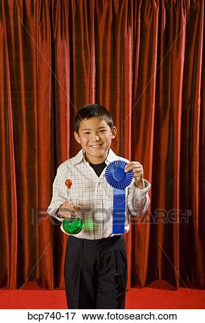 Asian boy holding prize ribbon on stage View Large Photo Image Stock Photo - Asian boy holding prize ribbon on stage. Fotosearch