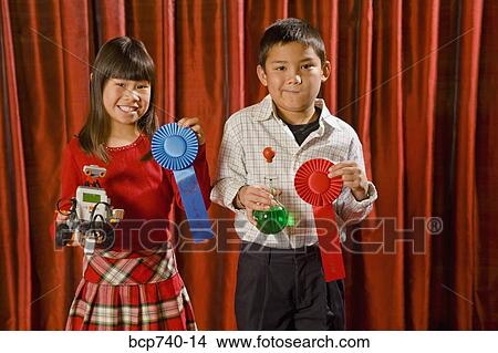 Asian girl and boy holding prize ribbons on stage View Large Photo Image Picture - Asian girl and boy holding prize ribbons on stage. Fotosearch