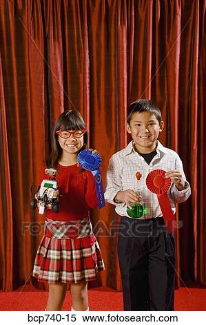 Asian girl and boy holding prize ribbons on stage View Large Photo Image Stock Photography - Asian girl and boy holding prize ribbons on stage. Fotosearch