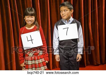 Asian girl and boy wearing numbers on stage View Large Photo Image Stock Image - Asian girl and boy wearing numbers on stage. Fotosearch