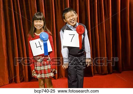 Asian girl and boy wearing prize ribbons on stage View Large Photo Image Stock Photography - Asian girl and boy wearing prize ribbons on stage. Fotosearch