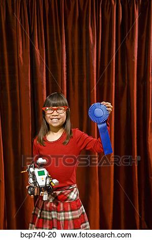 Asian girl holding prize ribbon on stage View Large Photo Image Stock Image - Asian girl holding prize ribbon on stage. Fotosearch