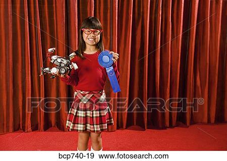Asian girl holding prize ribbon on stage View Large Photo Image Stock Photo - Asian girl holding prize ribbon on stage. Fotosearch