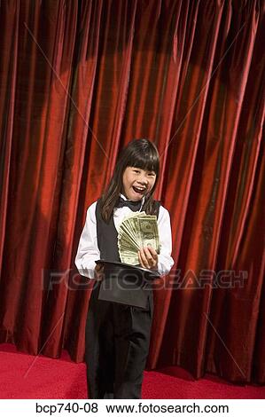 Asian girl pulling money out of top hat View Large Photo Image Stock Photo - Asian girl pulling money out of top hat. Fotosearch