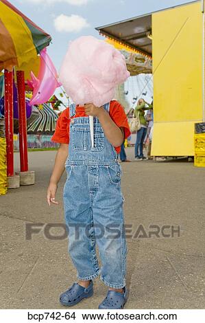 Boy holding cotton candy in front of face View Large Photo Image Picture - Boy holding cotton candy in front of face. Fotosearch