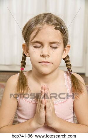 Girl praying with eyes closed View Large Photo Image Stock Photograph - Girl praying with eyes closed. Fotosearch