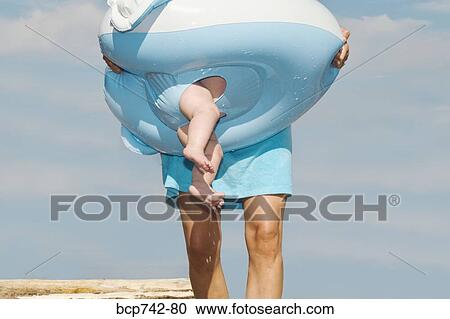 Mother carrying baby in float View Large Photo Image Stock Image - Mother carrying baby in float. Fotosearch