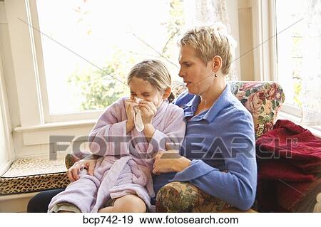 Mother watching sick daughter blow nose View Large Photo Image Stock Photo - Mother watching sick daughter blow nose. Fotosearch