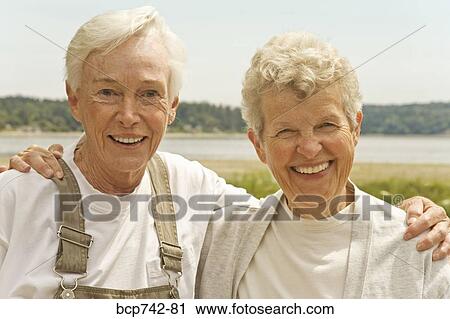 Stock Image - Senior women hugging outdoors. Fotosearch