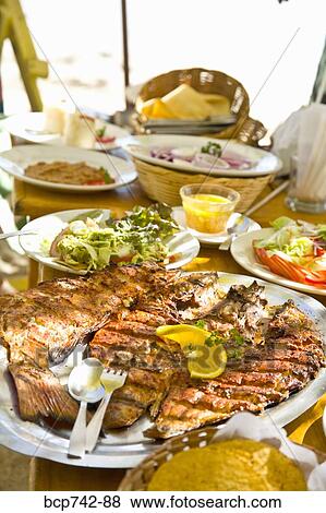 Table filled with plates of food View Large Photo Image Stock Photo - Table filled with plates of food. Fotosearch