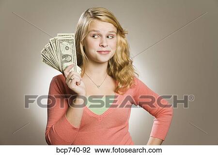 Teenage girl holding fanned out money View Large Photo Image Stock Image - Teenage girl holding fanned out money. Fotosearch