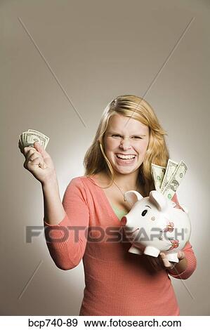 Teenage girl holding money and piggy bank View Large Photo Image Stock Photo - Teenage girl holding money and piggy bank. Fotosearch