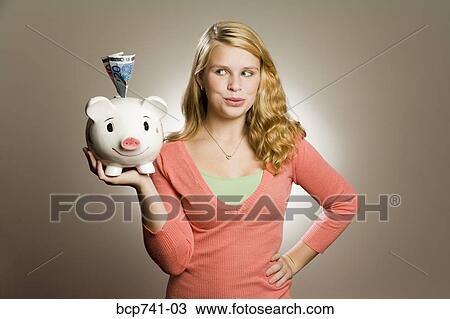Teenage girl holding piggy bank with money View Large Photo Image Stock Image - Teenage girl holding piggy bank with money. Fotosearch