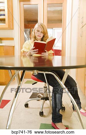 Teenage girl reading at table View Large Photo Image Stock Photograph - Teenage girl reading at table. Fotosearch