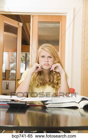 Stock Photography - Teenage girl studying and frowning. Fotosearch