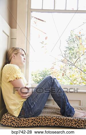 Stock Photo - Teenaged girl looking out window. Fotosearch