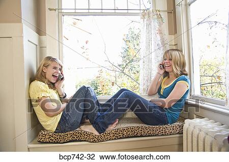 Teenaged sisters talking on cell phones View Large Photo Image Stock Image - Teenaged sisters talking on cell phones. Fotosearch