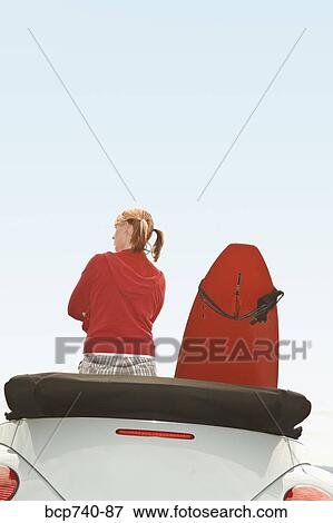 Woman and surfboard in convertible car View Large Photo Image Stock Photo - Woman and surfboard in convertible car. Fotosearch