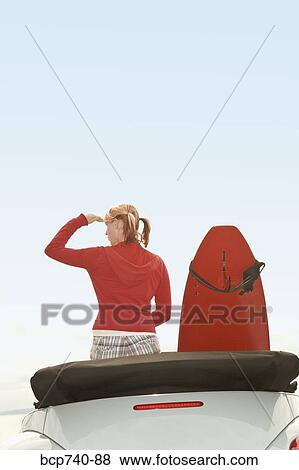 Woman and surfboard in convertible car View Large Photo Image Stock Photo - Woman and surfboard in convertible car. Fotosearch